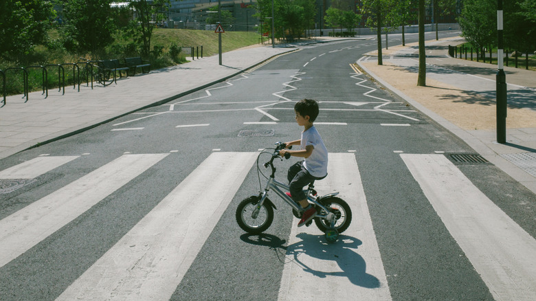 A child riding a bike on a crosswalk
