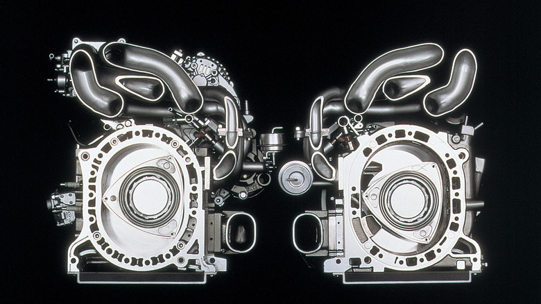2 Wankel rotary engines side-by-side with front faces removed exposing engine rotors and piping, front-view