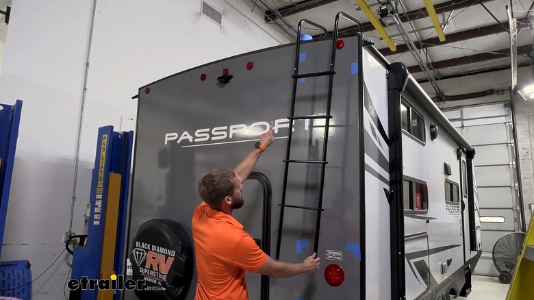 A Man Installing A Rear RV Ladder