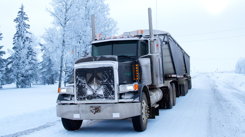 Semi truck with winterfront driving through the snow