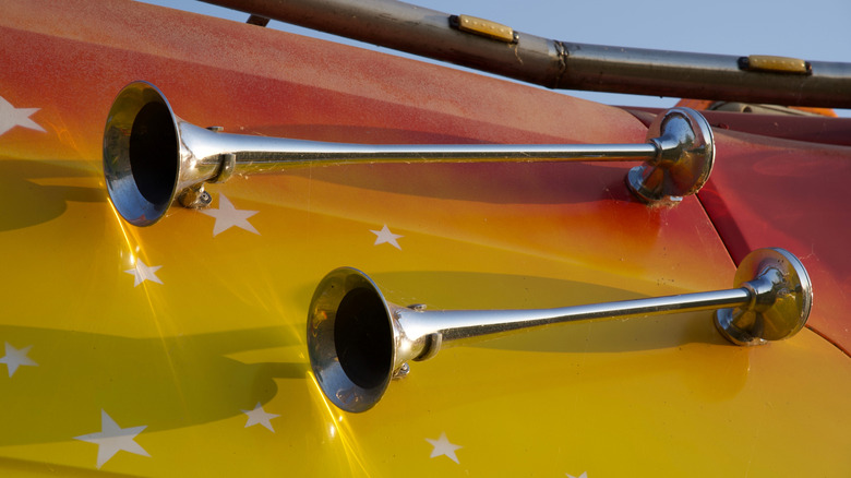 Two air horns positioned on top of colorful truck