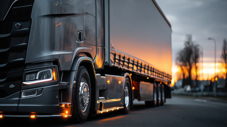 Low angle shot of semi truck driving at sunset