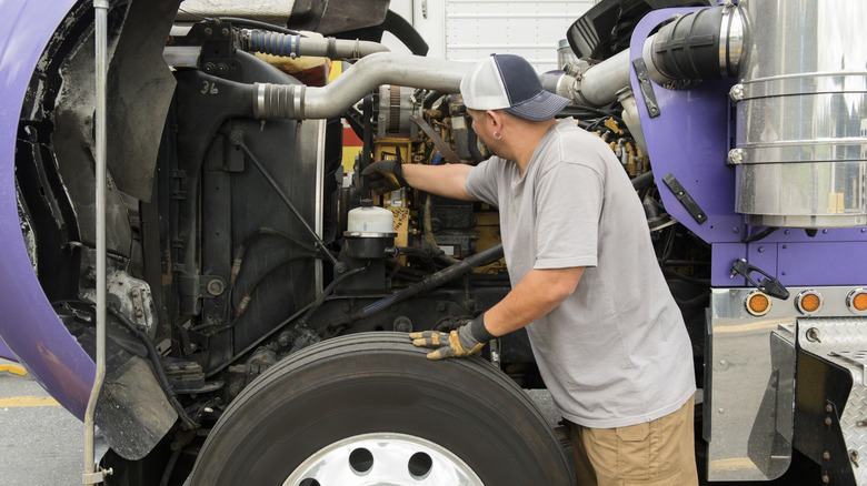 Person working on a semi-truck engine