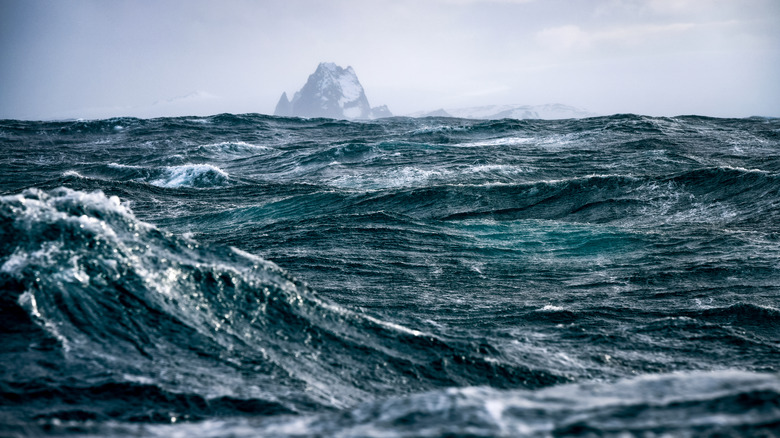 Rough and windy seas of the Drake Passage with the South Shetland Islands in the background.