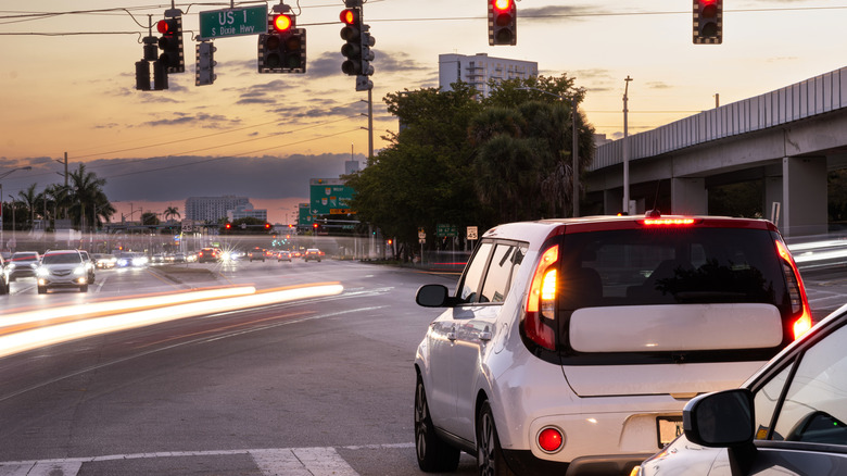 Cars waiting at a red traffic light at a busy city intersection