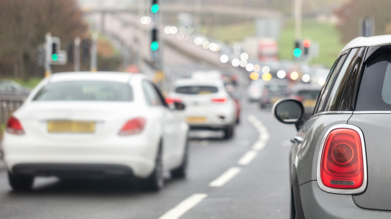 Cars setting off in line at a green traffic light