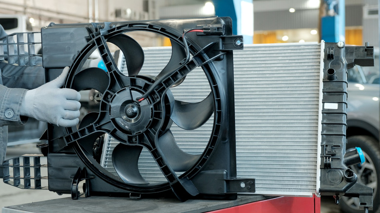 A radiator fan for an automobile engine being inspected before installation