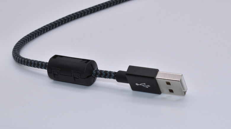 A black USB cable with cylinder at end