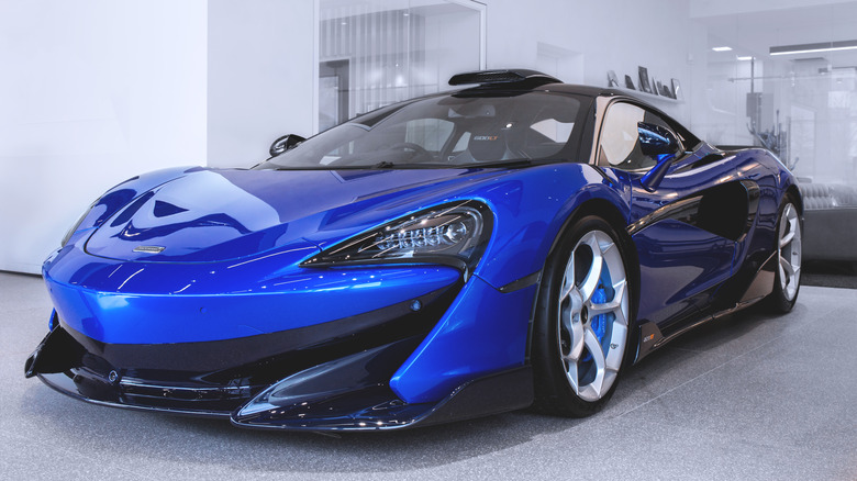 Blue McLaren 620R in garage from front left corner