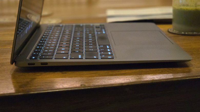 A sideview of a MacBook Air M1 on a wooden table
