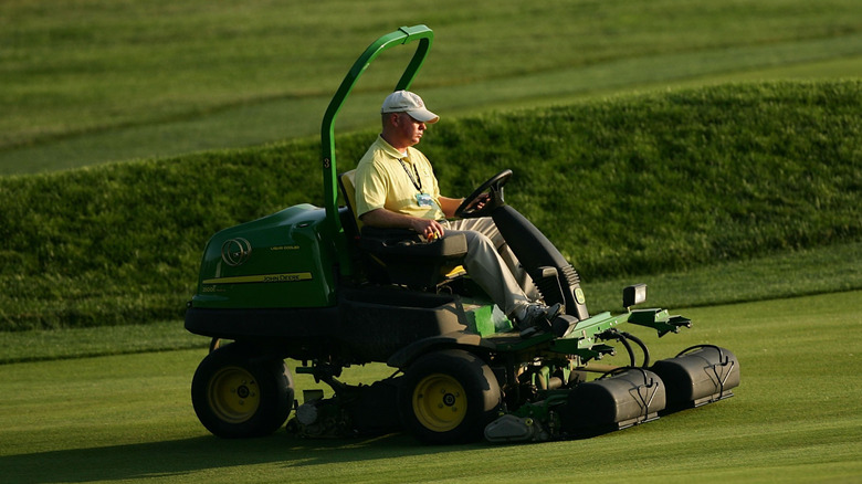 A member of the grounds crew operating a mower during the 107th U.S. Open Championship