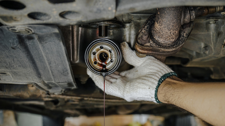 A used oil filter being removed from a car
