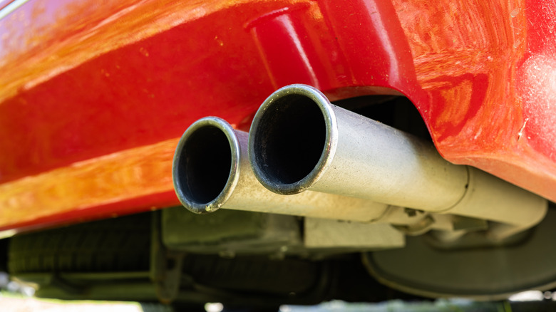 A close-up of a twin circular exhaust tips on a red car