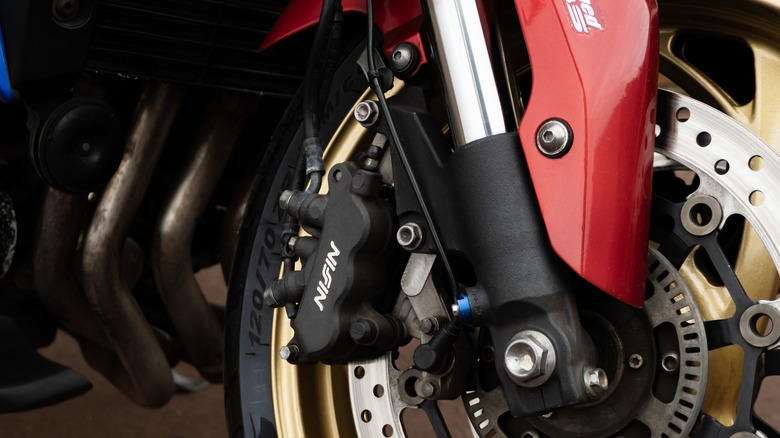 An inverted fork suspension on a parked red motorcycle