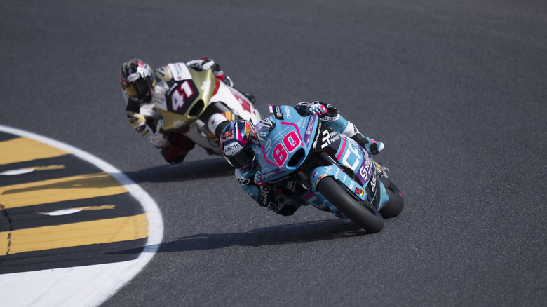 Two professional bike riders leaning at the curve