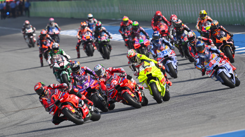 Multiple MotoGP riders performing knee dragging at the turn