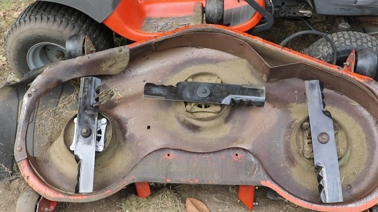 The underside of a mower deck with gator blades installed.