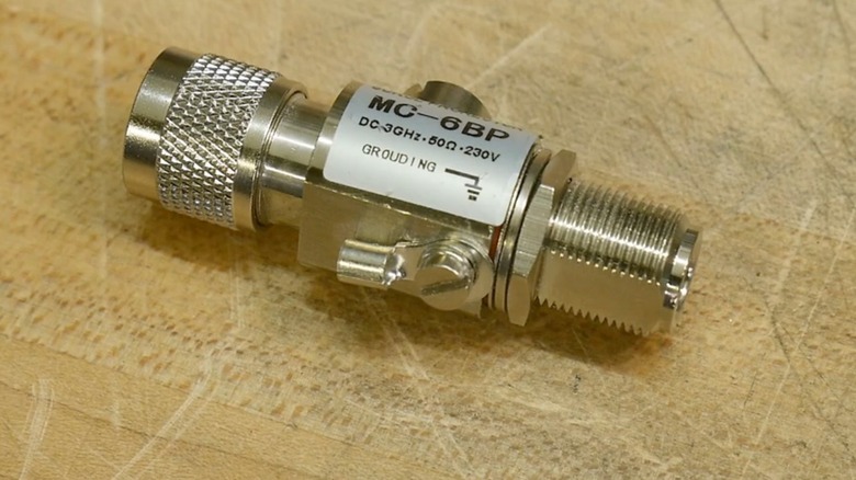A coaxial cable surge arrestor lying on a wooden tabletop