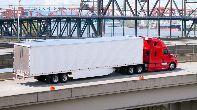 semi-truck trailer driving over bridge