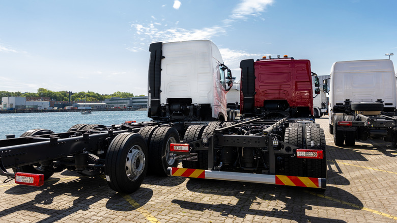 Two semi trucks with exposed frames sitting next to each other