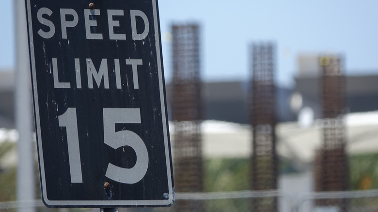 Black speed limit sign on road.