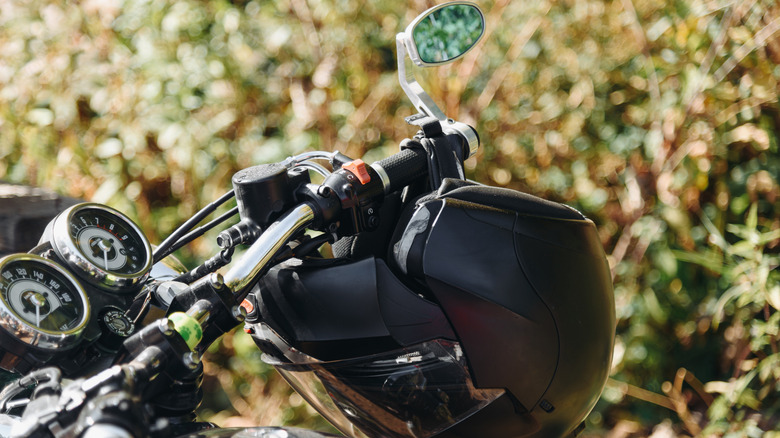 Motorcycle helmet hanging from motorcycle handlebar