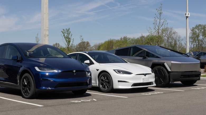 Tesla Model X, Model S, and Cybertruck display at a dealership.