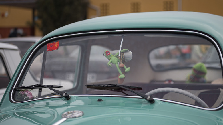 kermit toy on rearview mirror of a car