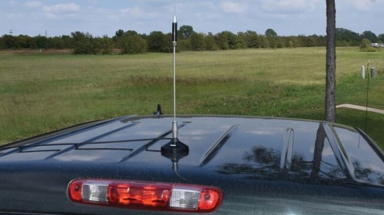 A whip antenna mounted on a truck roof.