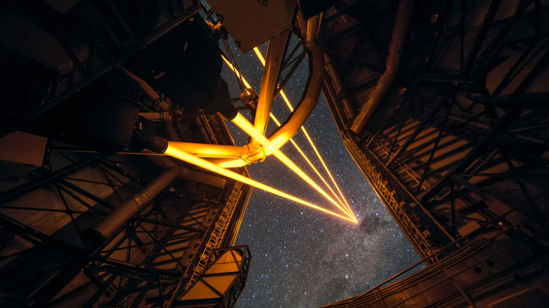 Four orange laser beams fire into the night sky from one of the telescopes at ESO's Very Large Telescope in Chile