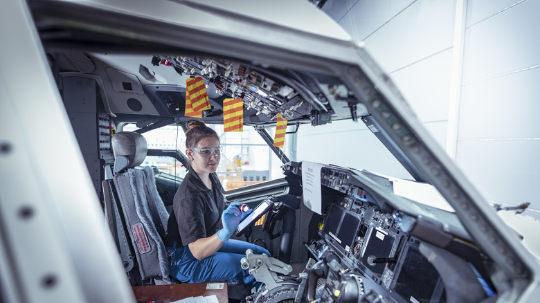 Technician inspecting airplane cockpit