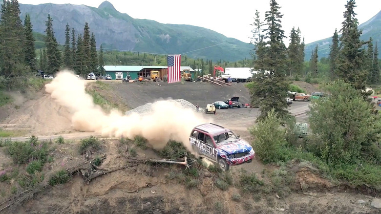 Decorated vehicle jumping off cliff under American flag