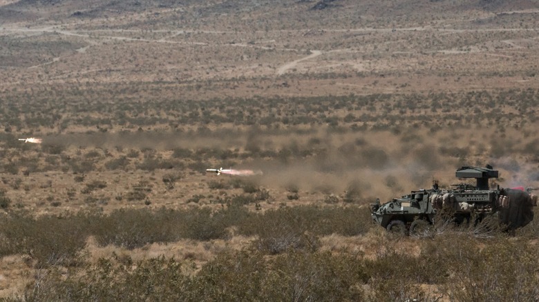 A pair of TOW missiles are launched from a military Jeep