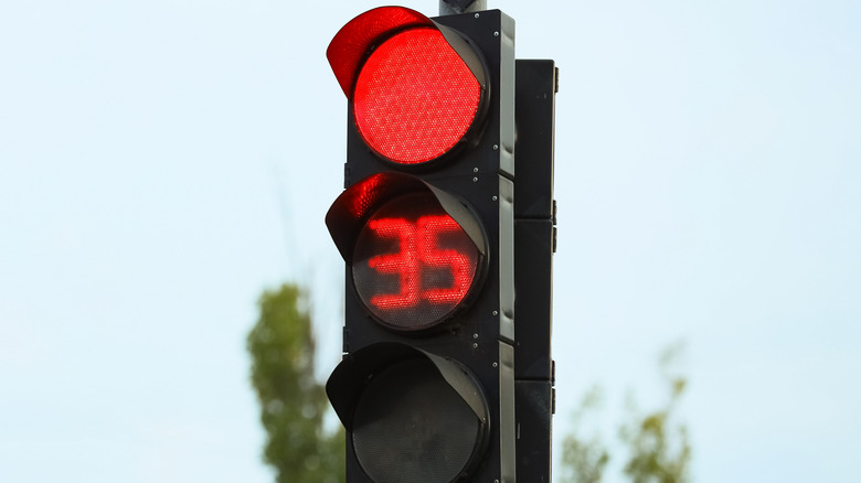 A traffic light with a countdown timer in the center.