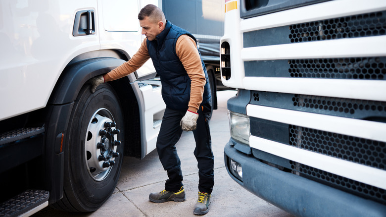Man inspecting semi tire