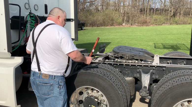 Man thumping semi tire