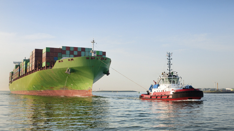 A Tugboat Pulling A Container Ship In Calm Uncongested Waters