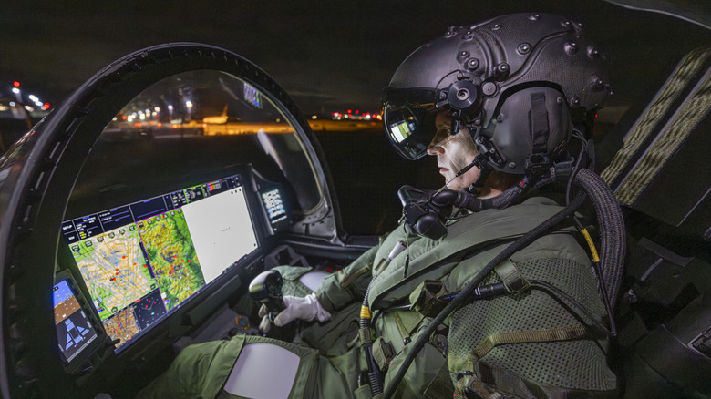 Pilot wearing Striker II Helmet in the cockpit of a fighter jet looking at map display