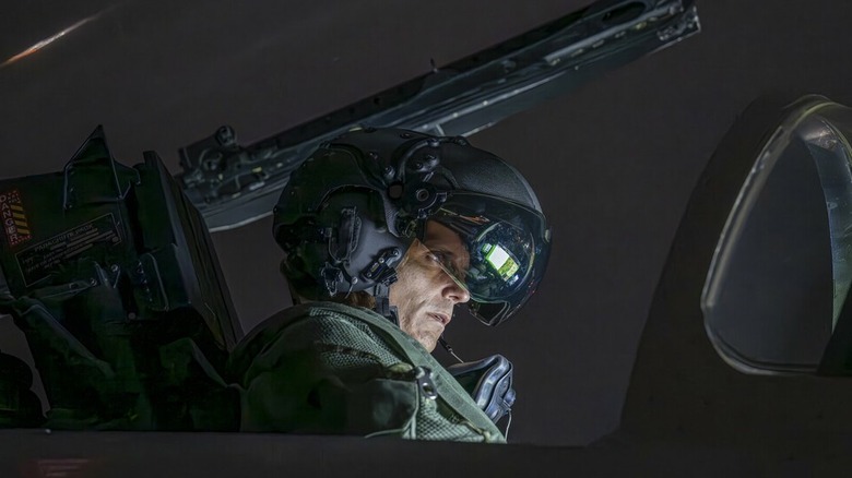 Pilot wearing the Striker flight helmet in the cockpit of a fighter jet at night