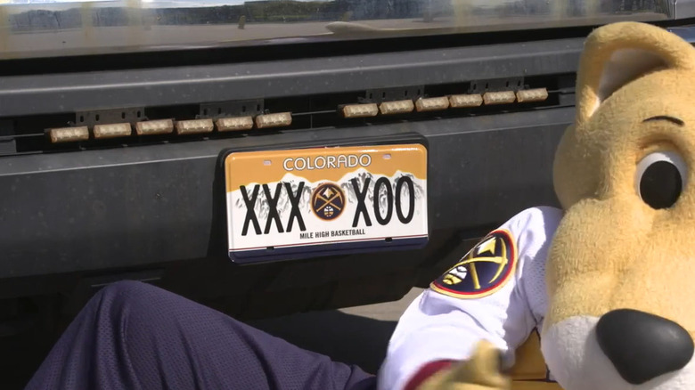 Denver Nuggets mascot next to car with Mile High Basketball license plate