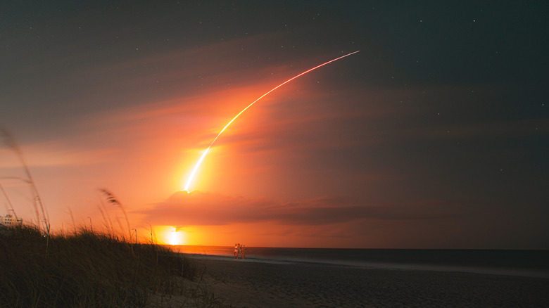 Rocket launch visible from a beach
