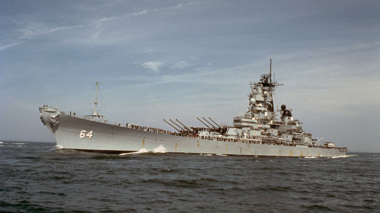Historic photo of sailors aboard a U.S. Navy ship perform "manning the rails" upon returning from a mission.