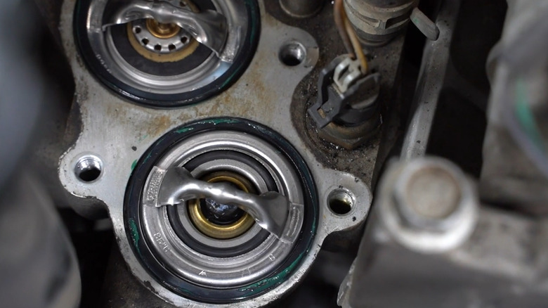 A close-up of the two thermostats in a Duramax diesel engine