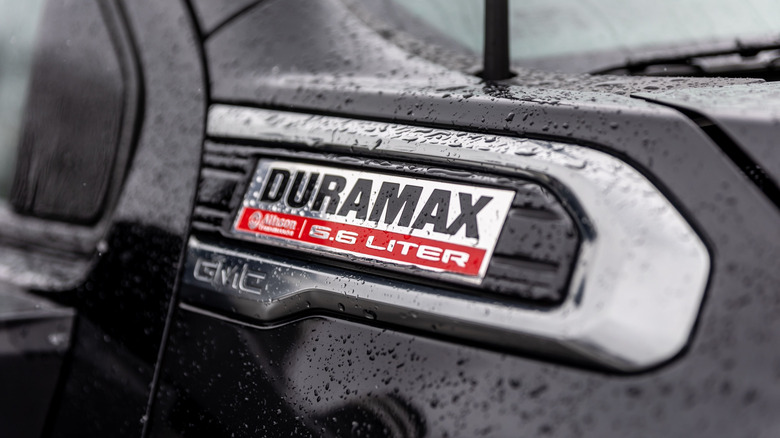 The Duramax 6.6-liter badge on the front fender of a GMC pickup truck