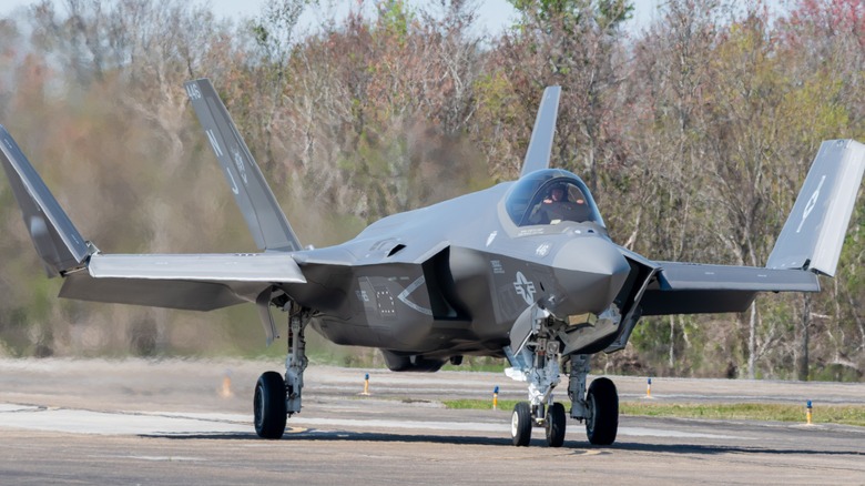 An F-35C on a runway with its wings folded.