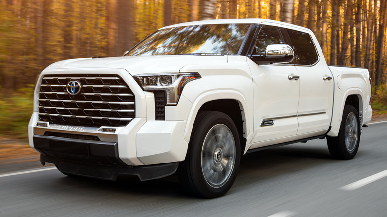 A white Toyota Tundra driving on a forested road