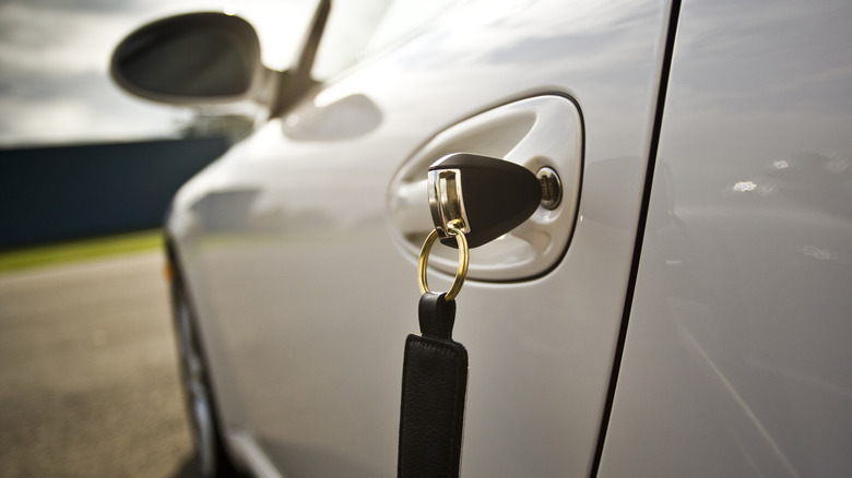 Metal key inserted into car door slot