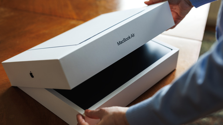 Person opening box with Apple MacBook Air inside