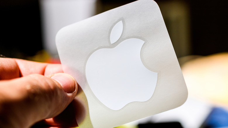 Person holding a single Apple sticker