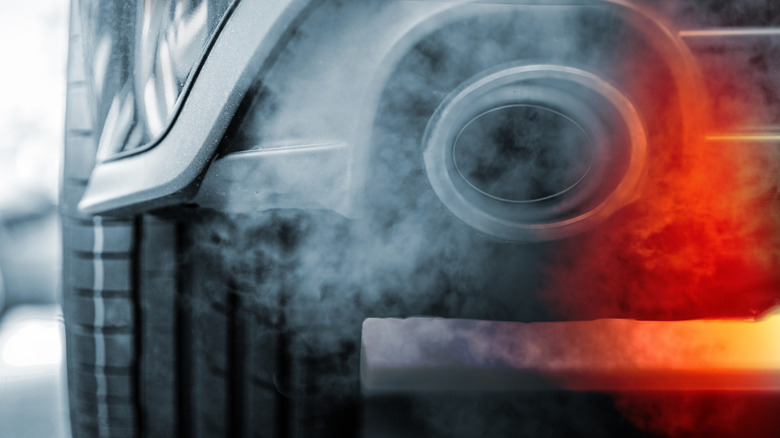 Smoke emission from exhaust pipe of SUV car